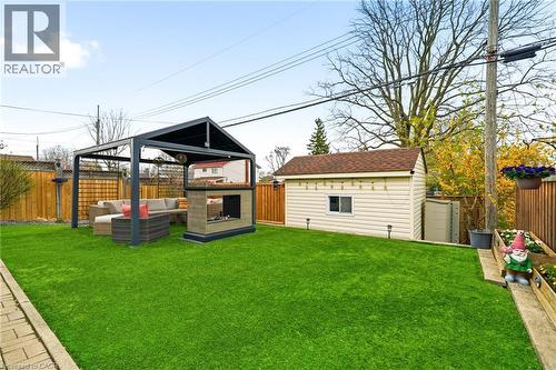 Artificial turf lawn featuring a contemporary gazebo with a built-in outdoor fireplace and a detached storage shed - 30 Darlington Drive, Hamilton, ON - Outdoor