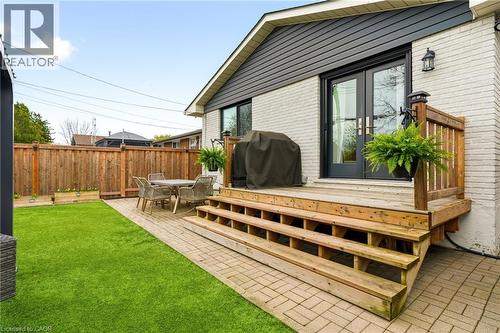 Rear exterior featuring a wood deck with multiple steps, a paver patio, and a fenced yard with artificial turf - 30 Darlington Drive, Hamilton, ON - Outdoor With Deck Patio Veranda