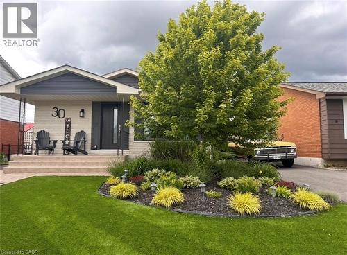Front exterior featuring light-colored brick and dark siding - 30 Darlington Drive, Hamilton, ON - Outdoor With Deck Patio Veranda