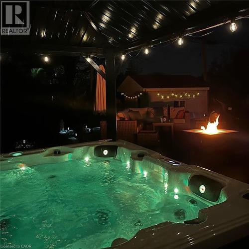 Outdoor spa with integrated lighting, covered by a permanent pergola featuring string lights - 30 Darlington Drive, Hamilton, ON - Indoor Photo Showing Other Room