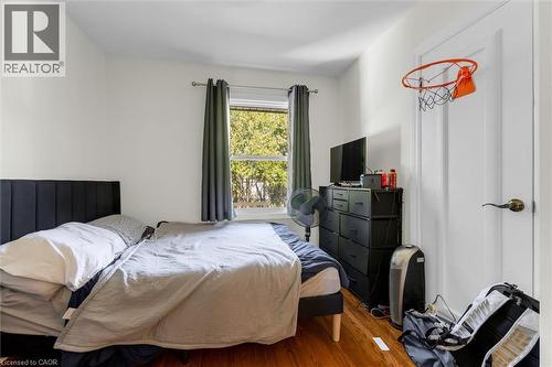 Bright interior room featuring a window with natural light, light-colored walls, and wood-finish flooring - 406 East 43Rd Street, Hamilton, ON - Indoor Photo Showing Bedroom