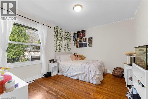 Spacious room featuring hardwood flooring, white baseboards, and a large window with white trim - 406 East 43Rd Street, Hamilton, ON - Indoor Photo Showing Bedroom