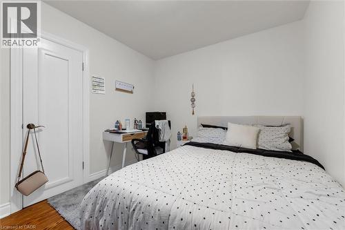 Hardwood-style flooring extends into this room featuring a white paneled door - 406 East 43Rd Street, Hamilton, ON - Indoor Photo Showing Bedroom