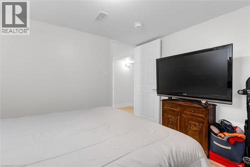 Neutral wall finishes, white trim, and light wood-finish flooring characterize this interior space - 406 East 43Rd Street, Hamilton, ON - Indoor Photo Showing Bedroom