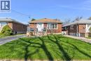 Brick facade residence with a light brown shingle roof, featuring a front porch with white railings and steps, multiple windows with white trim, and a concrete driveway - 406 East 43Rd Street, Hamilton, ON  - Outdoor 