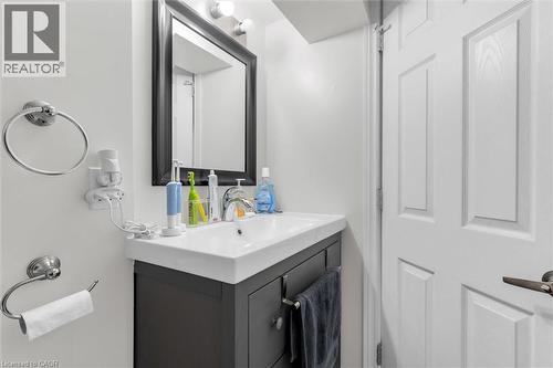 White vanity with an integrated sink and chrome faucet, set against a light-toned wall - 406 East 43Rd Street, Hamilton, ON - Indoor Photo Showing Bathroom
