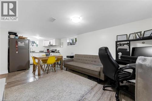 Open-concept living area with wood-finish flooring, a contemporary kitchen featuring white cabinetry, and a dedicated workspace - 406 East 43Rd Street, Hamilton, ON - Indoor