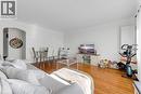 Open-concept living space featuring wood-finish flooring, white walls, crown molding, and an arched doorway - 406 East 43Rd Street, Hamilton, ON  - Indoor 