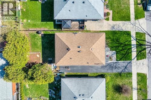 Aerial perspective showcasing the property's brown shingle roof, paved driveway, and established green lawn - 406 East 43Rd Street, Hamilton, ON - Outdoor
