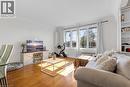 Living area featuring wood-finish flooring, a multipane window, built-in shelving, and white baseboards and crown molding - 406 East 43Rd Street, Hamilton, ON  - Indoor Photo Showing Living Room 