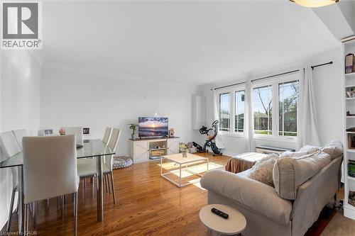 Expansive living area featuring wood-finish flooring and multiple large windows for abundant natural light - 406 East 43Rd Street, Hamilton, ON - Indoor Photo Showing Living Room