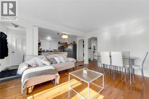 Spacious living area featuring wood-finish flooring, white walls, and arched doorways - 406 East 43Rd Street, Hamilton, ON - Indoor Photo Showing Living Room