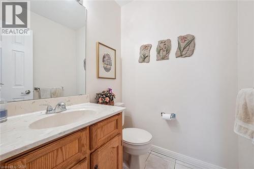 Bathroom featuring a wood vanity with an integrated sink, polished chrome faucet, and a large wall-mounted mirror - 42 Trailview Drive, Kitchener, ON - Indoor Photo Showing Bathroom