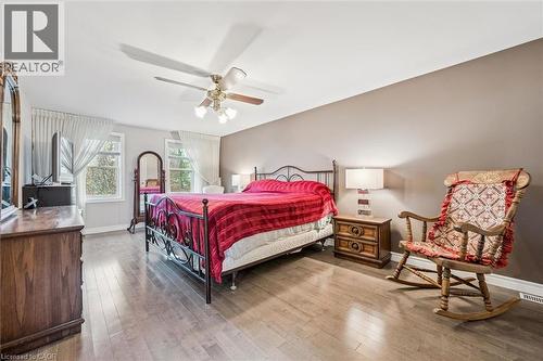Spacious room featuring wood-finish flooring, multiple windows, a ceiling fan with integrated lighting, and neutral wall tones - 42 Trailview Drive, Kitchener, ON - Indoor Photo Showing Bedroom