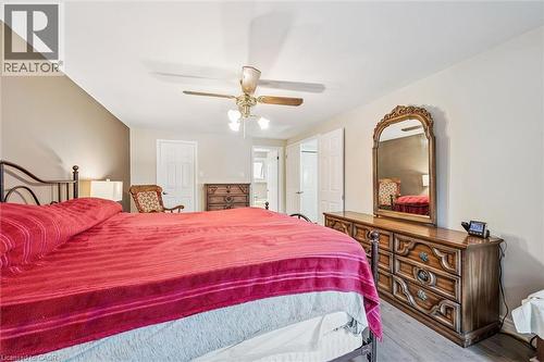 Spacious bedroom featuring wood-finish flooring, a ceiling fan with integrated lighting, and multiple doors providing access to other areas - 42 Trailview Drive, Kitchener, ON - Indoor Photo Showing Bedroom
