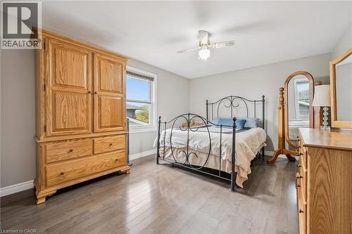Spacious room featuring wood-finish flooring, a ceiling fan with integrated lighting, and a single window with white trim - 42 Trailview Drive, Kitchener, ON - Indoor Photo Showing Bedroom
