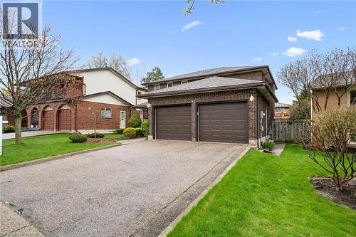 Brick exterior residence featuring a two-car garage with panel doors, a concrete driveway, and a shingled roof - 42 Trailview Drive, Kitchener, ON - Outdoor