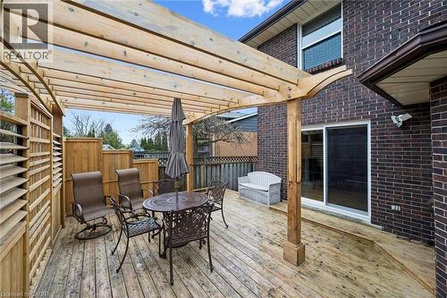 Expansive wood deck with an attached pergola, featuring a brick exterior, sliding glass door access, and wood fencing - 42 Trailview Drive, Kitchener, ON - Outdoor With Deck Patio Veranda With Exterior