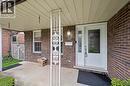 Covered front porch featuring a white screen door, decorative side window, and sconce lighting - 42 Trailview Drive, Kitchener, ON  - Outdoor With Exterior 