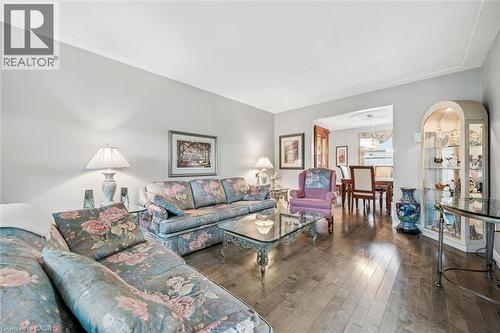 Spacious living area featuring wood-finish flooring, light grey walls, and crown molding - 42 Trailview Drive, Kitchener, ON - Indoor Photo Showing Living Room