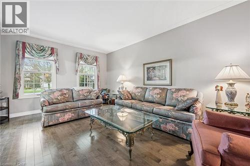 Spacious living area featuring wood-finish flooring, two large windows with white trim, light gray walls, and crown molding - 42 Trailview Drive, Kitchener, ON - Indoor Photo Showing Living Room