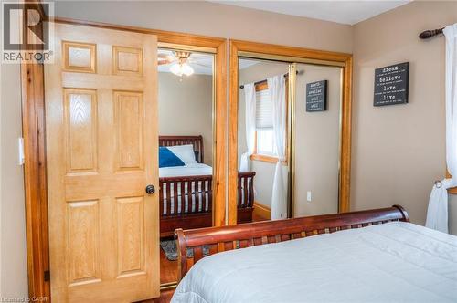 Bedroom featuring light wood-finish paneled door, wall-to-wall carpeting, and mirrored closet doors with gold-tone framing - 46 2 Avenue, Kitchener, ON - Indoor Photo Showing Bedroom
