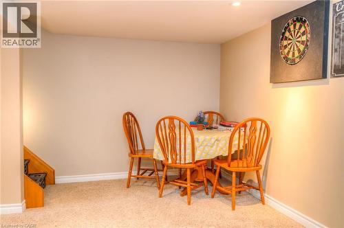 Carpeted room with recessed lighting, light beige wall paint, white baseboards, and a visible stairwell with wood trim - 46 2 Avenue, Kitchener, ON - Indoor
