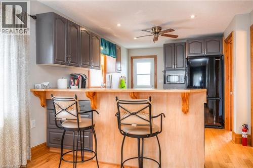 Kitchen featuring wood-finish flooring, gray cabinetry, a breakfast bar with a wood countertop, recessed lighting, and a ceiling fan - 46 2 Avenue, Kitchener, ON - Indoor Photo Showing Kitchen