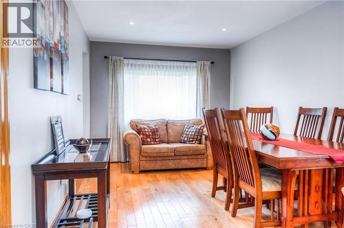 Bright open-concept interior featuring wood-finish flooring, recessed lighting, and a window with sheer and blackout curtains - 46 2 Avenue, Kitchener, ON - Indoor