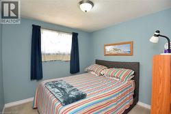 Interior room featuring a single window with curtain rods, light blue painted walls, and a textured ceiling - 