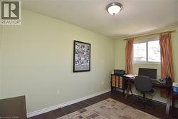 Room with light green walls and dark wood-finish flooring - 