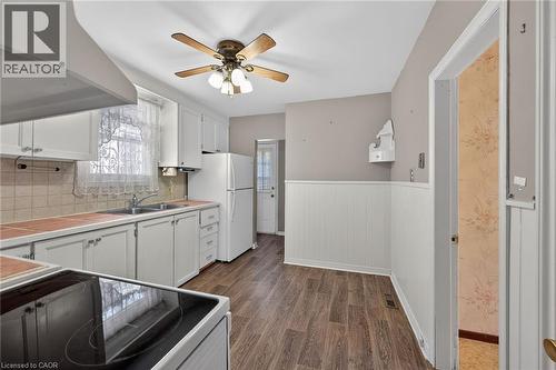 Kitchen featuring white cabinetry, a double basin sink, and a white refrigerator - 192 Ivon Avenue, Hamilton, ON - Indoor Photo Showing Kitchen With Double Sink