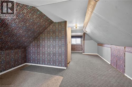 Attic space featuring sloped ceilings, patterned wallpaper accents, and a window for natural light - 192 Ivon Avenue, Hamilton, ON - Indoor Photo Showing Other Room
