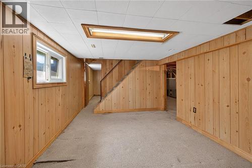Room with wood-panel walls, white drop ceiling, and light-colored carpeting - 192 Ivon Avenue, Hamilton, ON - Indoor Photo Showing Other Room