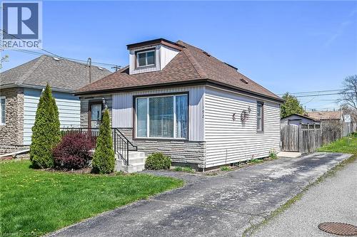 Single-story home featuring a dormer window, stone facade accents, and horizontal siding - 192 Ivon Avenue, Hamilton, ON - Outdoor