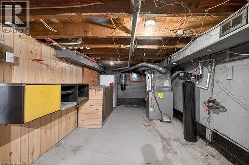 Basement utility area featuring exposed wood joists, a forced-air furnace, and a water filtration system - 192 Ivon Avenue, Hamilton, ON - Indoor Photo Showing Basement