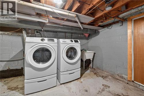Laundry area featuring a utility sink, concrete block walls, and exposed ceiling joists - 192 Ivon Avenue, Hamilton, ON - Indoor Photo Showing Laundry Room