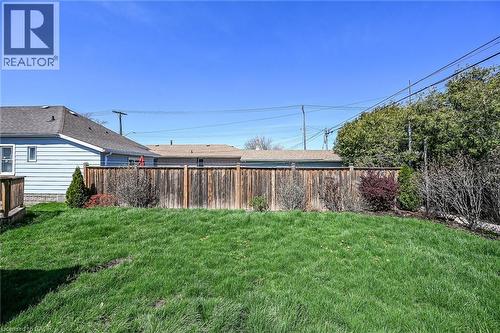 Expansive grassy yard area featuring a full-height wooden privacy fence - 192 Ivon Avenue, Hamilton, ON - Outdoor
