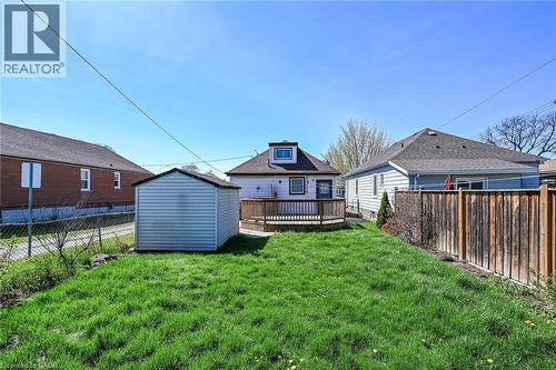 Expansive backyard featuring a green lawn, a wooden privacy fence, a storage shed, and a raised wooden deck - 192 Ivon Avenue, Hamilton, ON - Outdoor With Deck Patio Veranda With Exterior