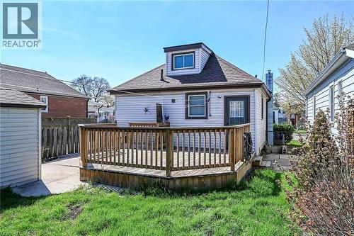 Rear exterior featuring a wooden deck with railing, white siding, and a dormer window - 192 Ivon Avenue, Hamilton, ON - Outdoor With Deck Patio Veranda