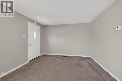 Spacious room with light gray walls, dark gray carpeting, and white baseboards - 192 Ivon Avenue, Hamilton, ON - Indoor Photo Showing Other Room