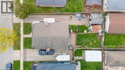 Property featuring a large main dwelling with a shingle roof, a detached garage, and a spacious backyard with green lawn - 