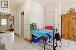 White tile flooring throughout, featuring a natural wood-finish storage cabinet with black hardware - 