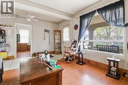 Living room featuring wood-finish flooring, a large picture window, and a ceiling fan - 