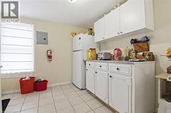 Kitchenette featuring white cabinetry, a light-colored countertop, and a white refrigerator - 