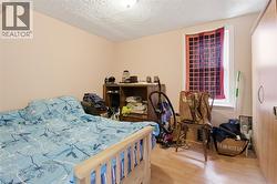 Room featuring light neutral wall paint, a window with trim, a ceiling-mounted light fixture, and wood-finish flooring - 