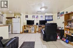 Open-concept area featuring light-toned tile flooring, recessed lighting, and a white ceiling - 