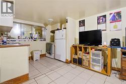 Kitchen area featuring a window, tile flooring, and a white refrigerator - 