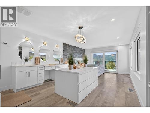 Designer-inspired primary walk-in closet featuring a central island and ample custom storage throughout. - 3859 Carrall Road, West Kelowna, BC 