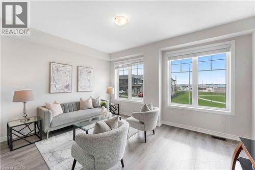 Bright living space featuring large windows, wood-finish flooring, white baseboards, and neutral wall tones - 50 Hollywood Court, Cambridge, ON - Indoor Photo Showing Living Room